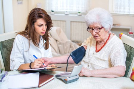 Foto de Enfermera revisando pacientes presión arterial - Imagen libre de derechos