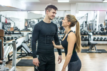 Photo for Beautiful young woman and man flirting in gym - Royalty Free Image