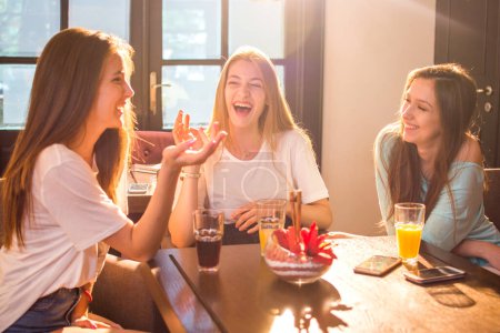 Foto de Adolescentes felices hablando y riendo en un café. - Imagen libre de derechos
