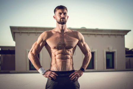 Photo for Sexy athletic man showing muscular body and six-pack abs outdoors. - Royalty Free Image