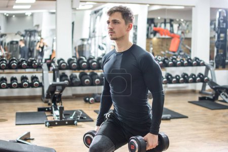 Téléchargez les photos : Musclé jeune homme faire de l'exercice de fente avec des poids dans la salle de gym - en image libre de droit