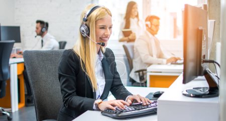 Foto de Retrato del joven ejecutivo de servicio al cliente en auriculares que trabajan en la computadora en el centro de llamadas - Imagen libre de derechos