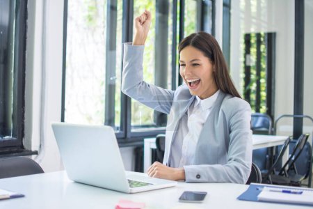 Photo for Happy excited woman triumphing with fist up in office. - Royalty Free Image