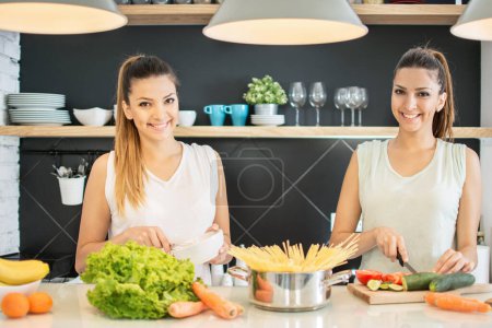 Téléchargez les photos : Jumeaux cuisiner dans la cuisine - en image libre de droit