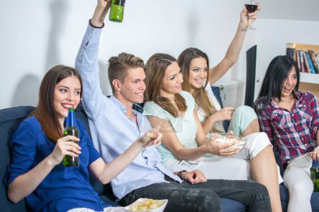 Photo for Group of young friends watching TV match and cheering - Royalty Free Image