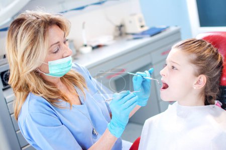 Photo for Young girl getting her teeth examined by professional female dentist in dental clinic - Royalty Free Image