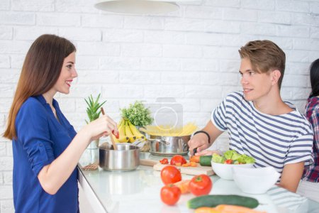 Téléchargez les photos : Jeune couple cuisine dans la cuisine - en image libre de droit