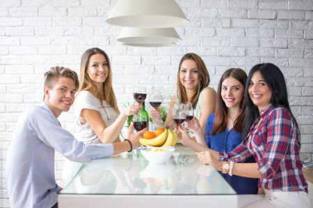 Foto de Grupo de cinco amigos bebiendo vino en casa - Imagen libre de derechos