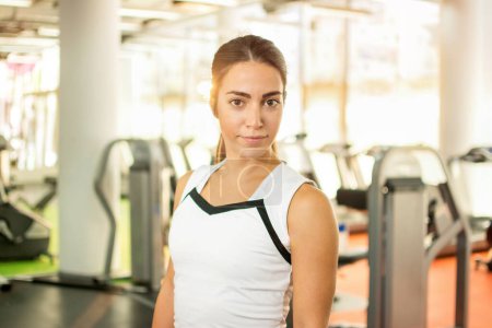 Téléchargez les photos : Portrait de femme fitness posant dans la salle de gym. - en image libre de droit