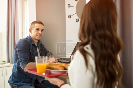 Téléchargez les photos : Petite amie apportant le petit déjeuner à son petit ami - en image libre de droit