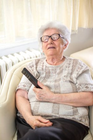Porträt einer Seniorin, die zu Hause auf einem Sessel schläft.