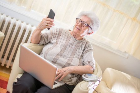 Foto de Mujer mayor usando tecnología moderna. - Imagen libre de derechos
