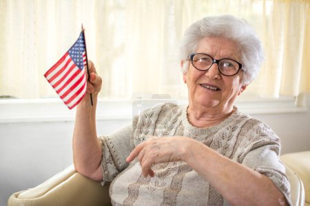 Photo for Portrait of happy senior woman holding USA flag. - Royalty Free Image