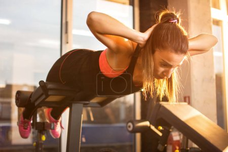 Téléchargez les photos : Jeune femme sportive séance d'entraînement sur la machine d'exercices dans la salle de gym
. - en image libre de droit