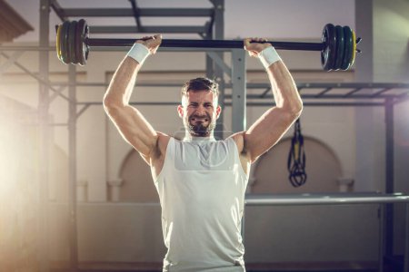 Photo for Man lifting barbells outdoors at rooftop gym. - Royalty Free Image