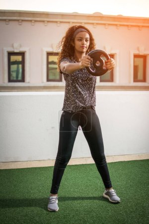 Téléchargez les photos : Jeune sportive séance d'entraînement avec poids à l'extérieur. - en image libre de droit