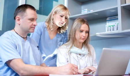 Group of healthcare workers with laptop working together in office