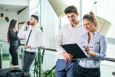 Téléchargez les photos : Jeune femme d'affaires interviewant son collègue masculin dans la salle de bureau - en image libre de droit