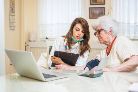 Krankenschwester misst Blutdruck einer Seniorin