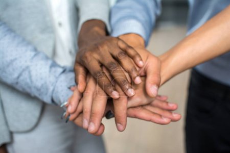 Téléchargez les photos : Les gens d'affaires multiraciaux empilant les mains les uns sur les autres - en image libre de droit