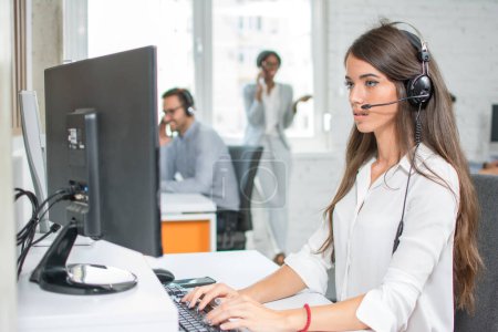 Téléchargez les photos : Bel opérateur de support client travaillant dans un bureau de centre d'appels. - en image libre de droit