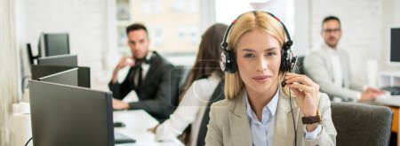 Photo for Portrait of beautiful female customer support operator with headset in call center - Royalty Free Image