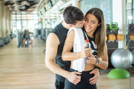 Foto de Feliz joven pareja deportiva compartiendo momentos románticos en el gimnasio - Imagen libre de derechos