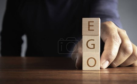 Téléchargez les photos : Ego sur des blocs d'alphabet en bois lisant - Ego - équilibré dans la paume de sa main dans une image conceptuelle - en image libre de droit
