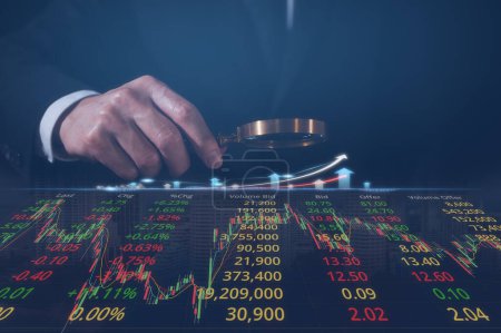 Téléchargez les photos : Homme d'affaires détenant du verre grossissant examinant les données boursières du graphique de trading pour l'analyse du marché et la stratégie financière - en image libre de droit