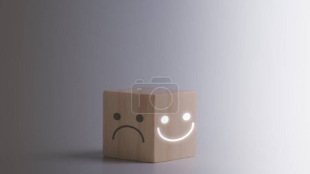 customer review, satisfaction and emotion concept, Smile face in bright side and sad face in dark side on wooden block cube for positive mindset selection, Mental health and emotional state concept