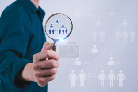 Man holding magnifying glass with HR people icon in team management for success in business plan Strategic Hiring  and HR concept Recruit Team Leader from Organization Chart