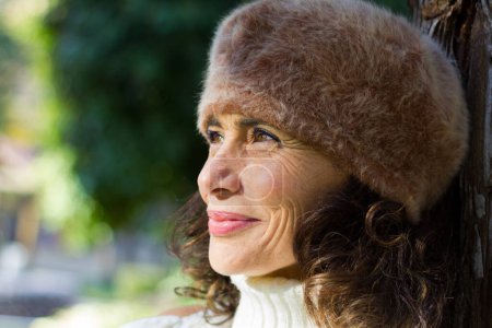 Photo for Attractive middle aged woman close up wearing fur beret hat and white turtle neck sweater. Portrait of beautiful mature lady with warm clothes. Fall fashion sales concept - Royalty Free Image