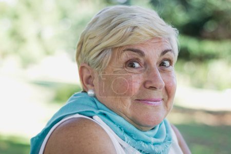 Photo for Close up of lovely blond senior lady with hopeful look in her eyes outdoors. Portrait of pretty mature woman with surprise expression in the park, entrepreneur, positive thinking concepts - Royalty Free Image