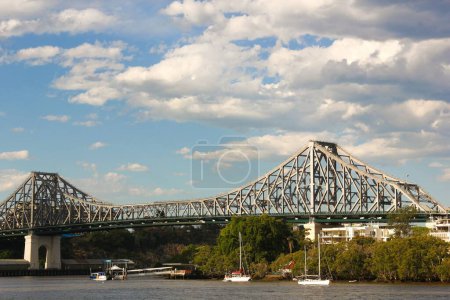 Téléchargez les photos : Story Bridge au-dessus de Brisbane River avec voiliers par temps nuageux, Queensland, Australie - en image libre de droit