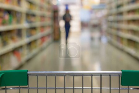 Foto de Primer plano en el supermercado carrito de compras frontal en pasillo borroso. Compra de comestibles concepto - Imagen libre de derechos