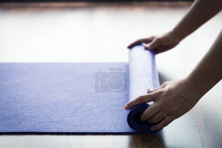 Photo for Woman at Yoga class with purple mat - Royalty Free Image