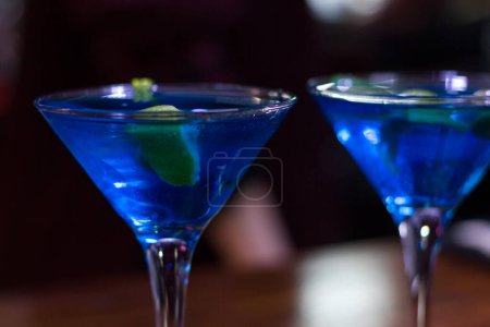 Photo for Blue drink fancy glasses with green olive and lemon slice. Martini cocktail - Royalty Free Image