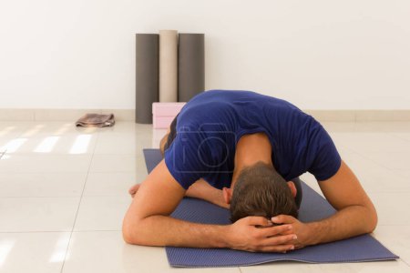 Photo for Man Yoga student stretching body at class. - Royalty Free Image