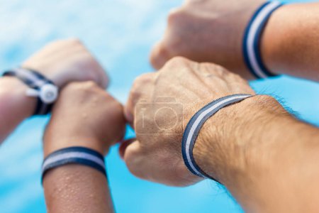 Photo for Father, mother and children hands with all inclusive bracelets. Family team by swimming pool, summer vacation, holiday resort, hotel package, fun, joy concepts - Royalty Free Image