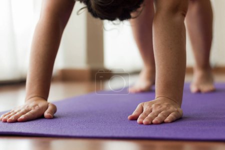 Photo for Woman on mat at Yoga class, partial view - Royalty Free Image