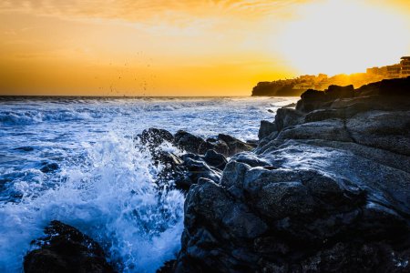Téléchargez les photos : Coucher de soleil orange vif ciel et eau de mer, falaises rocheuses - en image libre de droit