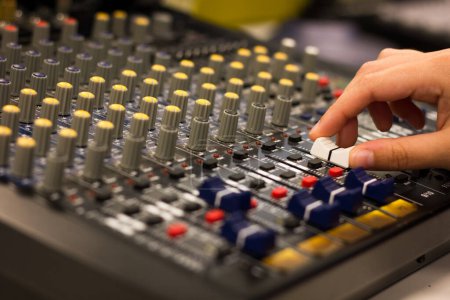 Photo for Hand of woman adjusts equalizer on mixing console. Sound engineer working on professional audio mixer. Music recording studio concept - Royalty Free Image