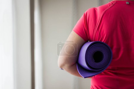 Téléchargez les photos : Femme tenant tapis de yoga violet, image recadrée - en image libre de droit