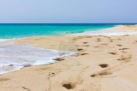 Photo for Footprints along seashore on empty beach with turquoise water. Nobody on colorful sea of tropical island. Idyllic summer holidays destination concept - Royalty Free Image