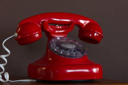 Photo for Classic red telephone. Retro style table phone with white cord. Communication, call service, dial, old fashioned, antique technology concepts. Vintage effect - Royalty Free Image