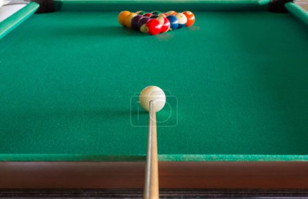 Photo for Pool table and balls set ready to start the game with the cue stick aiming white cue ball. Leisure time, new game, start concepts - Royalty Free Image