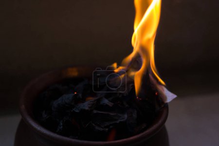 Téléchargez les photos : Papiers brûlant sur un pot d'argile brune. Souvenirs passés retrait rituel, engagement de promesse, concepts de preuves brûlantes - en image libre de droit