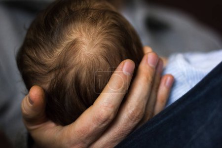 Téléchargez les photos : La tête du nouveau-né repose sur les mains de papa en dormant. Amour, soins, confiance, concepts de dépendance - en image libre de droit