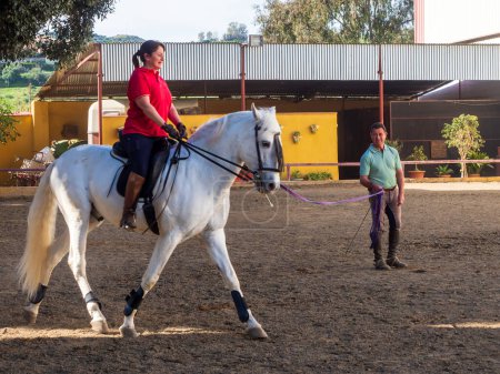 Téléchargez les photos : Femme à cheval recevant des cours d'équitation - en image libre de droit