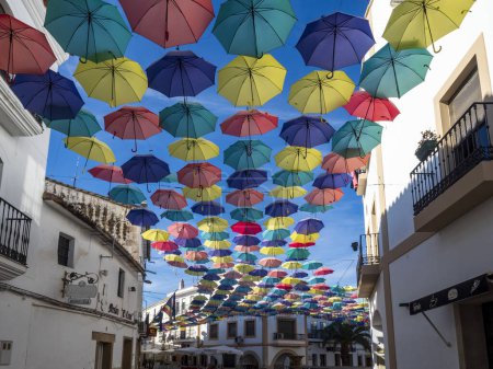 Téléchargez les photos : Parasols colorés dans la rue de la ville espagnole de malpartida dans la province de caceres. espagne. - en image libre de droit